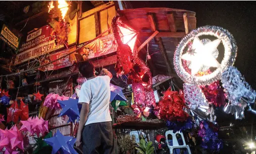  ??  ?? A VENDOR sorts hand-made Christmas parols he is selling near Cogon public market in Cagayan de Oro City. MindaNews photo by FROILAN GALLARDO