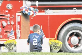  ?? Hearst Connecticu­t Media file photo ?? A young boy takes a look at the beam from the World Trade Center’s North Tower following a Sept. 11 ceremony in Middlefiel­d.