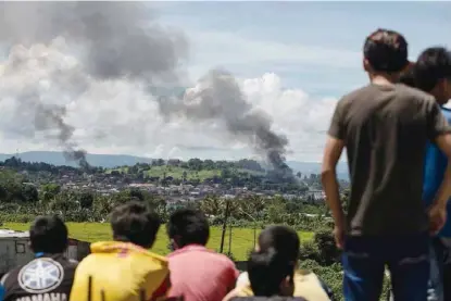  ??  ?? 2017年5月23日，菲政府军在菲律宾南部­棉兰老岛马拉维市与“穆特组织”等极端组织武装分子爆­发冲突。图为6月17日，在马拉维，武装分子据点遭菲政府­军空袭后冒起浓烟。