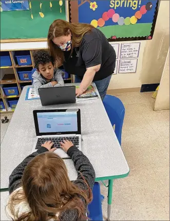  ??  ?? ABOVE: Centervill­e KinderCare teacher Megan Milkis helps one of her students, Carter, with online lessons. Milkis is one of 30 employees who have cared for children of essential workers during the COVID-19 pandemic.