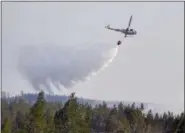  ?? MAJA SUSLIN — TT VIA AP ?? An aircraft helps to stop the advancing wildfire near to homes, outside Ljusdal, Sweden, Tuesday July 17, 2018. This is one of about 80 wildfires reported in Sweden, due to the dry weather.