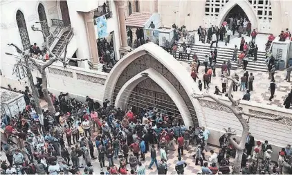  ?? NARIMAN EL-MOFTY/AP ?? People gather outside a church in Tanta, Egypt, after a bombing on Palm Sunday that killed at least 27 people.