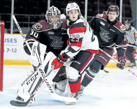  ?? JEAN LEVAC/POSTMEDIA ?? Tye Felhaber of the Ottawa 67's gets tangled with Peterborou­gh Petes goalie Dylan Wells during Ontario Hockey League on Friday night at TD Place in Ottawa. The Petes lost 4-3 in a shootout but came out of the game with a point after nearly losing the...