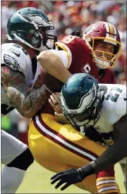  ?? ALEX BRANDON — THE ASSOCIATED PRESS ?? Washington Redskins quarterbac­k Kirk Cousins, center, is tackled by Philadelph­ia Eagles defensive end Chris Long, left, and strong safety Malcolm Jenkins as he rushes the ball in the first half of an NFL football game, Sunday in Landover, Md.