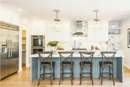  ??  ?? Thick marble slabs adorn a stylish and classical chef’s kitchen inside the West Clay Park home.