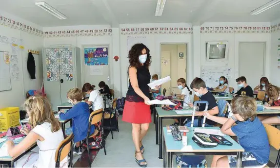  ??  ?? Sicurezza in classe Gli alunni di una scuola elementare al loro primo giorno in classe dopo il lungo periodo di stop. Distanze rispettate e misure igieniche osservate