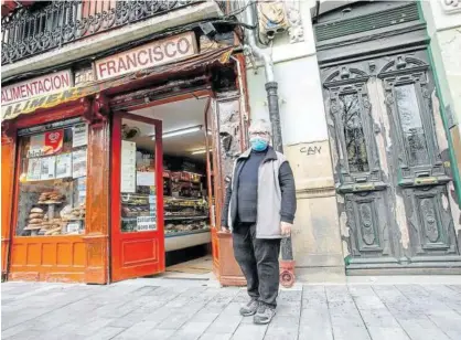  ??  ?? Conchi González posa junto a su tienda de alimentaci­ón afectada por los disturbios.