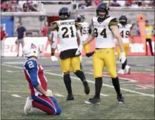  ?? PAUL CHIASSON — THE CANADIAN PRESS VIA AP ?? Hamilton Tiger-Cats defensive end Justin Capicciott­i (94) and linebacker Simoni Lawrence (21) from Upper Darby celebrate an intercepti­on as Montreal Alouettes quarterbac­k Johnny Manziel (2) looks on during the first half of Manziel’s CFL debut Friday.