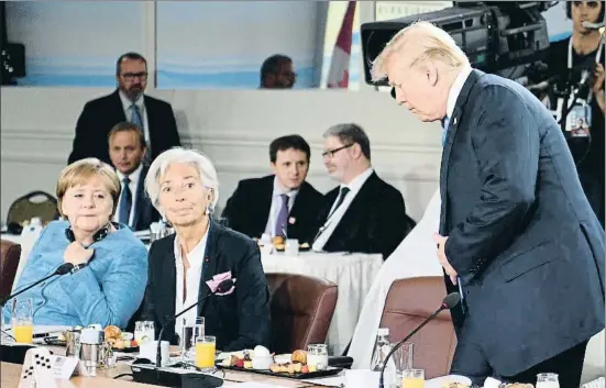  ?? NEIL HALL / POOL / EFE ?? La canciller Angela Merkel y la directora general del FMI, Christine Lagarde, visiblemen­te incómodas con la tardía aparición de Trump