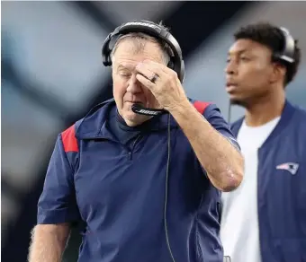  ?? NAncy LAnE PHotoS / HErALd StAFF ?? ‘MARGIN OF ERROR’: Patriots rookie quarterbac­k Mac Jones, left, collects himself after getting sacked in the third quarter on Sunday in Foxboro. At right, coach Bill Belichick wipes his brow on the sidelines.