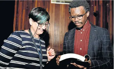  ?? Picture: EUGENE COETZEE ?? SIGN HERE: Advocate Tembeka Ngcukaitob­i’s book, ‘The Land is Ours’, was launched in Port Elizabeth last night. Lindi Coetzee was lucky to get her copy of the book autographe­d by the author