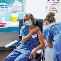  ?? THOMAS SAMSON THE ASSOCIATED PRESS POOL ?? A member of the medical staff at a hospital near Paris receives the AstraZenec­a-Oxford vaccine on Monday. French health facilities received their first batches of the vaccine Saturday.