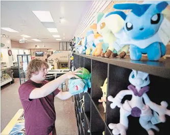  ?? JASON BAIN EXAMINER ?? Josh Johnston puts a stuffie on a shelf at Dodrio, his George St. store that offers bubble teas, anime merchandis­e and a gaming lounge, on Wednesday. Late last month, he closed the nearbyThin City Skateshop.