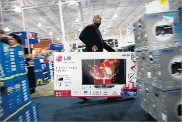  ?? Spencer Platt Getty Images ?? A SHOPPER carries a discounted big-screen television at a Best Buy store in Naples, Fla., on Black Friday in 2013. The day after Thanksgivi­ng is traditiona­lly one of the busiest days on the calendar for retailers.