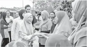  ??  ?? DR Wan Azizah (tiga,kiri) bersalaman dengan para penduduk pada Program Karnival Mini Keluarga Bestari sewaktu berkempen bagi Pilihan Raya Kecil (PRK) P.132 Port Dickson di Taman Intan Perdana, Telok Kemang, pada Ahad. -Gambar Bernama