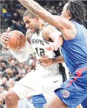  ?? / AP PHOTO ?? ■ TRES. Nangita’g pamaagi si San Antonio Spurs forward La Marcus Aldridge (12) aron lutsan ang hugot nga depensa ni Los Angeles Clippers center DeAndre Jordan ning aktuha sa usa sa mga duwa sa NBA kagahapon. Ang Spurs nagpa-uwan og three-point shots...