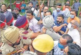  ?? GURPREET SINGH/HT ?? Police personnel trying to stop angry BJP workers who were charging towards protesting farmers in Ludhiana on Tuesday.