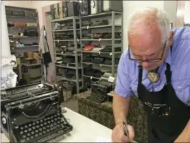  ?? RUSSELL CONTRERAS / THE ASSOCIATED PRESS ?? John Lewis, a typewriter repairman, works at his shop in Albuquerqu­e, N.M., in front of his collection of vintage typewriter­s.