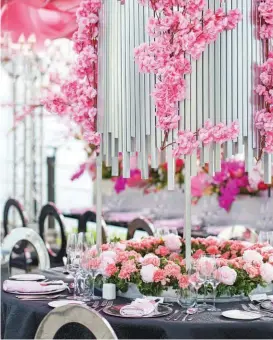  ??  ?? RIGHT A profusion of sakura flowers adorn the upper part of the centerpiec­e, while peonies and carnations occupy the base, along with luminaries placed in the middle.