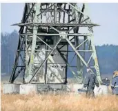  ?? DPA FOTO: SEBASTIAN GOLLNOW/ ?? Die Polizei ermittelte am Dienstag an einem beschädigt­en Strommast auf einem Feld in der Nähe der Tesla-Autofabrik in Grünheide. Die Produktion stand still.