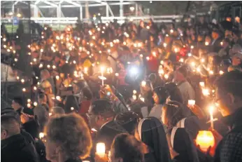  ??  ?? OUTPOURING OF GRIEF: Mourners hold candles during a vigil for the victims of the mass shooting at the San Manuel Stadium in San Bernardino, California.