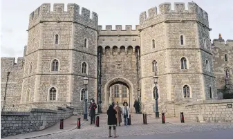  ?? ALBERTO PEZZALI, AP ?? People take photos at the entrance of Windsor Castle, in Windsor, near London. The British Army said Tuesday it has launched an urgent investigat­ion after an intruder posing as a priest reportedly spent the night at the barracks of troops who guard the Queen at Windsor Castle.