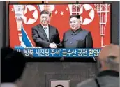 ?? JUNG YEON-JE/GETTY-AFP ?? People in Seoul watch a TV showing North Korean leader Kim Jong Un greeting Chinese President Xi Jinping.