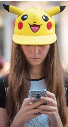  ?? FOTO: ARMESTRE/AFP ?? Klarer Fall von Pokémon-Sucht: Ein Mädchen mit einem „Pikachu“-Hut, dem bekanntest­en Pokémon, beim Spielen in Madrid.