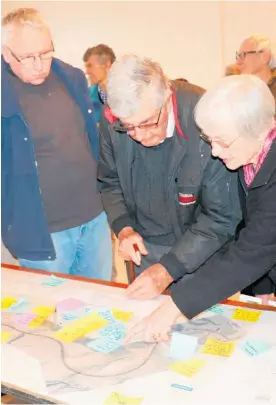  ??  ?? Mike Harold (left), and former Tararua mayor Bob Trotter and his wife Janet, check out the suggestion­s people have made on the proposed new route.