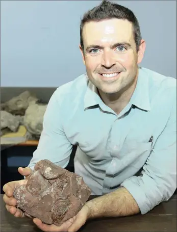  ??  ?? DINOSAUR SPECIALIST: Jonah Choiniere holds the 200 million-year-old Grenoble in France to be scanned last month.
Massospond­ylus egg block, which was taken to