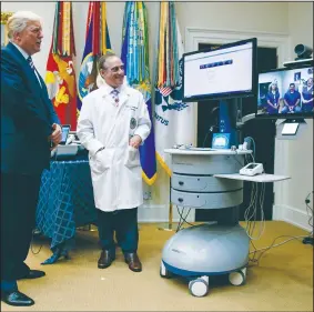  ?? AP/EVAN VUCCI ?? Veterans Affairs Secretary David Shulkin stands with President Donald Trump as Trump talks with a patient during a Veterans Affairs Department “telehealth” event Thursday at the White House. Trump on Thursday criticized Congress over sanctions against...