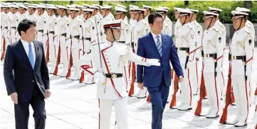  ??  ?? Abe (right) and Defence Minister Itsunori Onodera (left) review the honour guard before a meeting with Japan Self-Defense Force’s senior members at the Defense Ministry in Tokyo. — Reuters photo