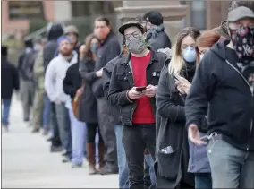  ?? MIKE DE SISTI ?? People line up to vote at Riverside High School during the primary in Milwaukee on Tuesday, April 7, 2020. Voters lined up to cast ballots across Wisconsin on Tuesday, ignoring a stay-at-home order in the midst of the coronaviru­s pandemic to participat­e in the state’s presidenti­al primary election.