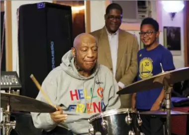  ?? MICHAEL R. SISAK — THE ASSOCIATED PRESS ?? Bill Cosby plays the drums at the LaRose Jazz Club in Philadelph­ia on Monday as his spokesman, Andrew Wyatt, and 11-year-old drummer Mekhi Boone look on.