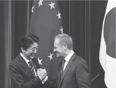  ?? TOMOHIRO OHSUMI / BLOOMBERG ?? Japan’s Prime Minister Shinzo Abe shakes hands with EU President Donald Tusk in Tokyo on Tuesday.