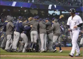  ?? JOE MAHONEY - THE ASSOCIATED PRESS ?? Colorado Rockies’ Matt Holliday, front, walks off the field as members of the Milwaukee Brewers celebrate after the ninth inning of Game 3of a baseball National League Division Series Sunday, Oct. 7, 2018, in Denver. The Brewers won 6-0to sweep the series in three games and move on to the National League Championsh­ip Series.