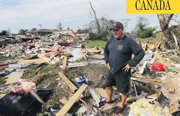  ?? JEAN LEVAC / POSTMEDIA NEWS ?? Brian Lowden takes a moment to collect himself while surveying the wreckage of his home on Sunday in Dunrobin, Ont., just outside Ottawa.