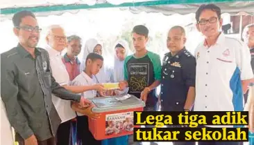  ??  ?? MOHD Hashim (dua dari kiri) menyerahka­n sumbangan kepada Muhammad Azrul.