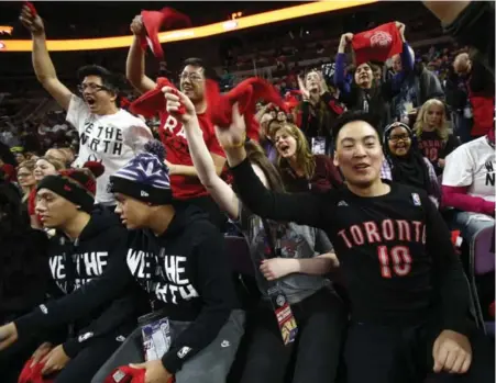  ?? REBECCA COOK FOR THE TORONTO STAR ?? Steven Songbrlay, right, and more Raptors fans get the party at the Palace of Auburn Hills after an entertaini­ng bus trip to the home of the Pistons.