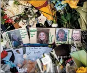  ?? JAKE MAY — THE FLINT JOURNAL VIA AP, FILE ?? Photograph­s of four students — Hana St. Juliana, 14; Madisyn Baldwin, 17; Tate Myre, 16; and Justin Shilling, 17 — sit among bouquets of flowers, teddy bears and other personal items left at the memorial site, Dec. 7, 2021, outside Oxford High School in Oxford, Mich.