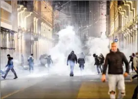  ?? CLAUDIO FURLAN / LAPRESSE VIA AP ?? Clashes break out on Oct 26 during a protest against measures imposed by the authoritie­s to curb the spread of COVID-19 in Turin, Italy.