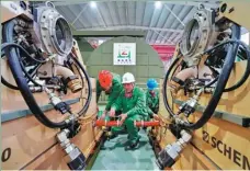  ??  ?? Veteran Han Hongsheng (center) and technician­s check equipment at his mechanical and electrical maintenanc­e company in Qianxi, Hebei province.