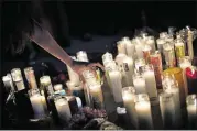  ?? DREW ANGERER / GETTY IMAGES ?? Mourners light candles in memory of the Las Vegas shooting victims.