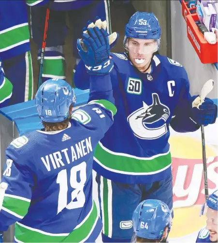  ?? JEFF VINNICK/GETTY IMAGES ?? Bo Horvat celebrates with Jake Virtanen after their 4-3 victory in Game 2 of the qualificat­ion round against the Minnesota Wild. The Canucks’ captain was seventh in the NHL this season in faceoff percentage, while teammates J.T. Miller and Jay Beagle were second and third.