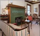  ??  ?? A fireplace with a green tile surround serves as a lovely focal point in the library.