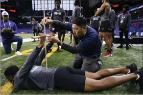  ?? THE ASSOCIATED PRESS ?? Denver Broncos scout Sae Woon Jo measures the flexiblity of Ball State defensive back Nic Jones at the NFL football scouting combine Friday, March 3, 2023, in Indianapol­is.