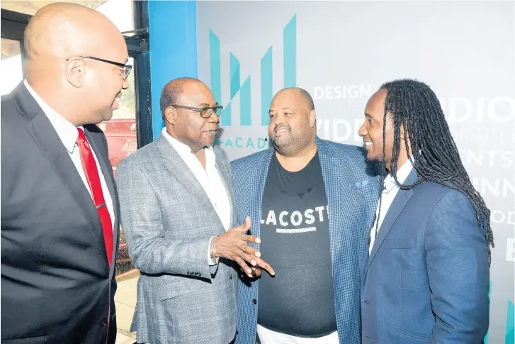  ??  ?? Minister of Tourism, Edmund Bartlett (second left) in dialogue with Alando Terrelonge (right), minister of state in the Ministry of Education, Youth and Informatio­n (right), and Solomon Sharpe (second right), CEO of Main Event Entertainm­ent Group Ltd, at the official launch of the M-Academy. Joining in the moment is Delano Seiveright, communicat­ions strategist at the Ministry of Tourism. M-Academy is a Jamaica Social Investment Fund and Main Events partnershi­p providing alternativ­e livelihood and skills developmen­t.