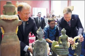  ?? (File Photo/AP/Heng Sinith) ?? Daniel Kritenbrin­k (from right), U.S. assistant secretary of state for East Asian and Pacific affairs, places jasmine bouquets on artifacts July 13 with Cambodian Minister of Culture and Fine Arts Phoeurng Sackona and U.S. Ambassador to Cambodia W. Patrick Murphy during a reception ceremony for a return of artifacts at Cambodia’s National Museum in Phnom Penh, Cambodia.