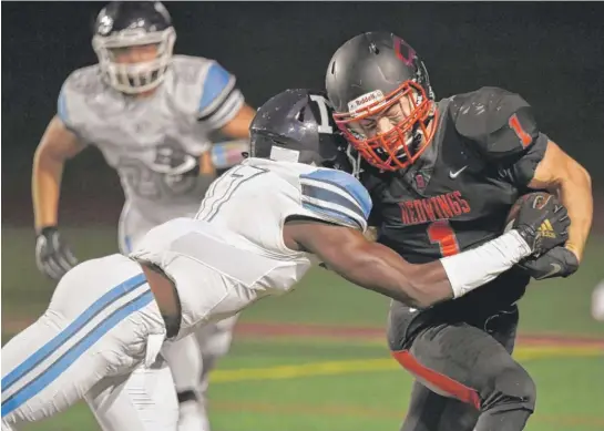  ?? JOHN STARKS/DAILY HERALD ?? Nazareth’s Diamond Evans (left), who caught six passes for 120 yards, hits Benet running back Ben Hickey in the first quarter Friday night.