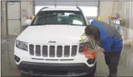  ?? Associated Press ?? A worker washes a Jeep at the service department of a LaFontaine auto dealership in Fenton Township, Mich., in January. A chain reaction touched off by the coronaviru­s pandemic has pushed new-vehicle prices to record highs and dramatical­ly driven up the cost of used ones.